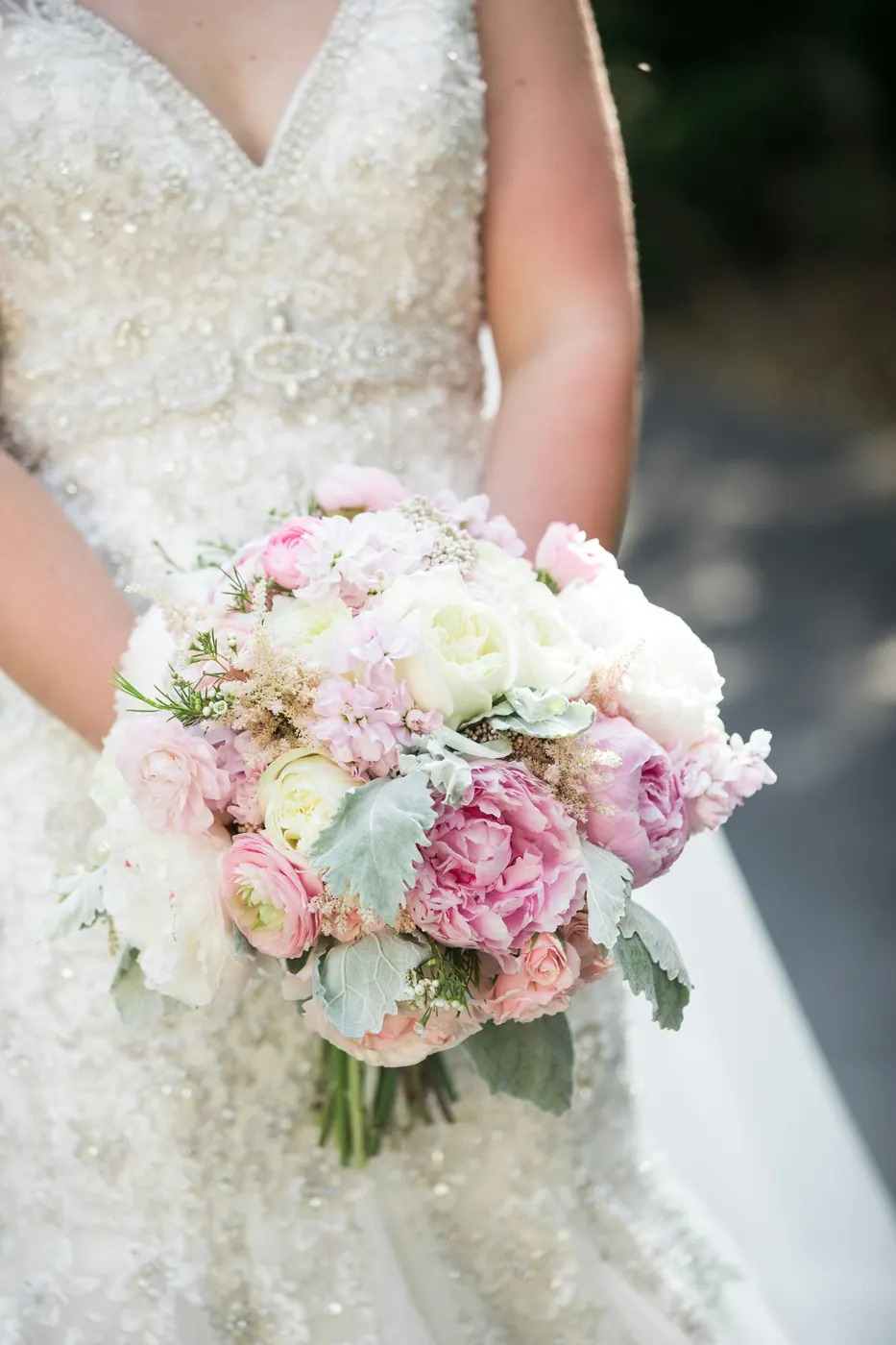 Une mariée tient un bouquet de fleurs roses