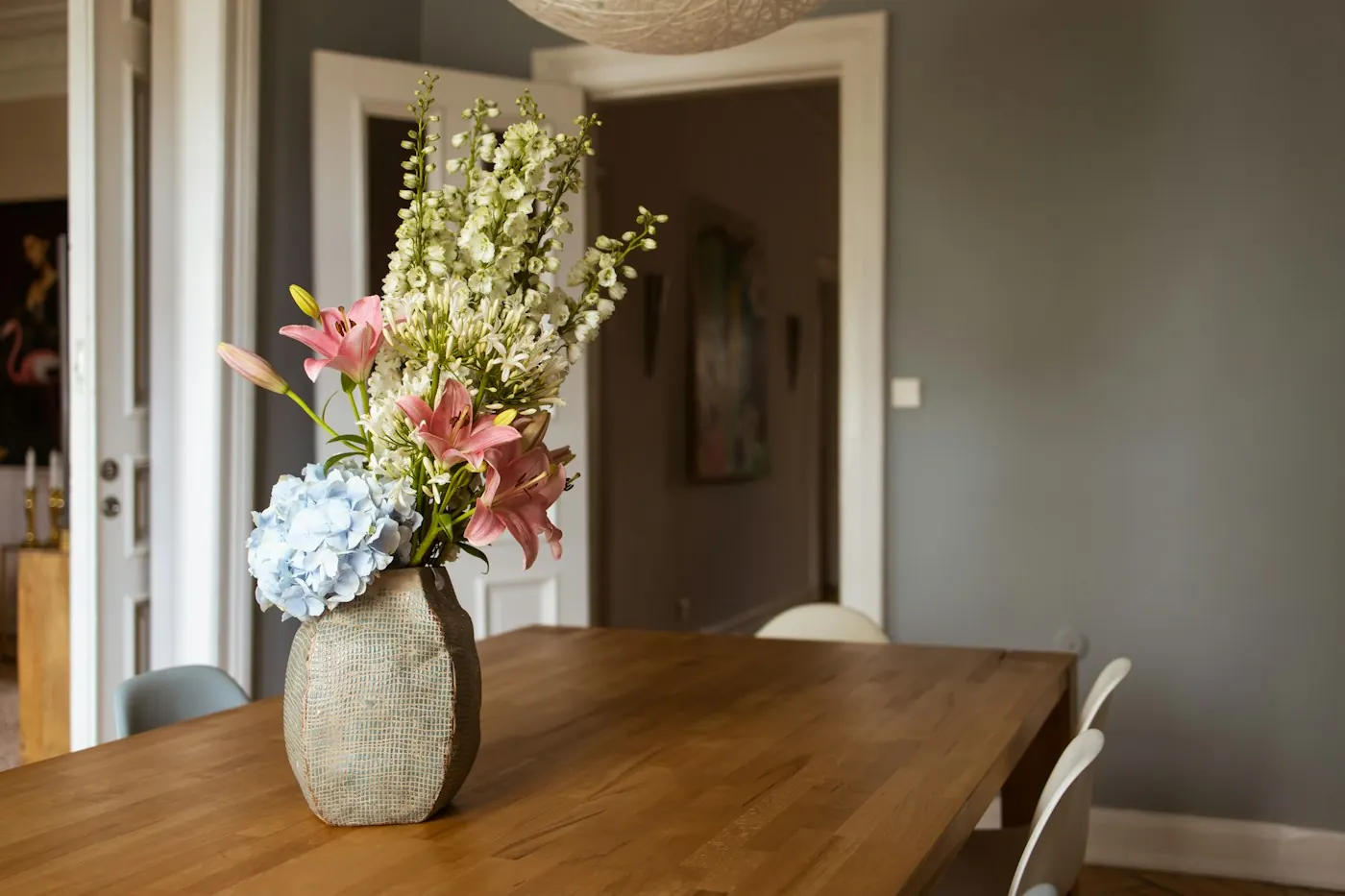 Grand vase de fleurs fraîches posé sur une table en bois massif